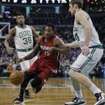Miami Heat guard Mario Chalmers (15) drives against Boston Celtics center Tyler Zeller (44) as Celtics guard Marcus Smart (36) watches in the first half of an NBA basketball game in Boston, Wednesday, March 25, 2015. (AP Photo/Elise Amendola)