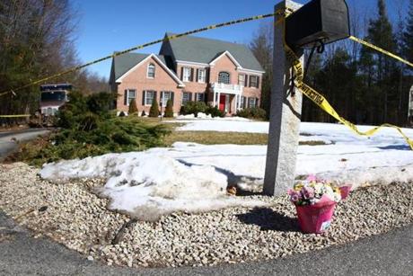 Flowers were placed by a mailbox at a house on McAfee Farm Road in Bedford where three people were foudn dead.

