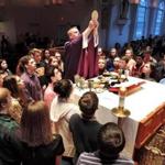 At the Life Teen Mass at St. Mary of the Sacred Heart Church in Hanover, youths gathered around the Rev. Chris Hickeyon the altar for the consecration of the eucharist. 