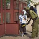 A young Christian boy is frisked with a metal detector and has his bag searched to prevent against possible attacks, as he enters the compound of the Our Lady of Consolation Church in Garissa, Kenya.