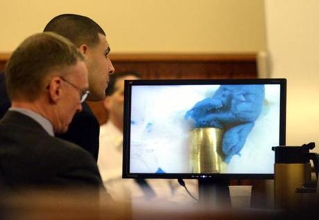 Aaron Hernandez (second from left) and attorney Charles Rankin viewed an image of bubble gum and a bullet shell during the trial Monday.
