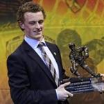 Boston University forward Jack Eichel smiles as he holds his trophy after winning the Hobey Baker Award, recognizing college hockey's top player, in Boston, Friday, April 10, 2015. (AP Photo/Charles Krupa)