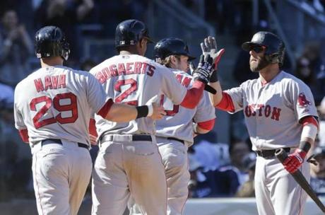 Dustin Pedroia (right) celebrates with Daniel Nava (29), Xander Bogaerts (2) and Ryan Hanigan (10) after they scored on a double by Brock Holt.
