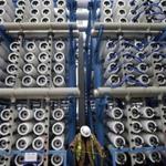 Reverse-osmosis chambers towered over a worker at the Poseidon Water desalination plant being built in Carlsbad, Calif. 