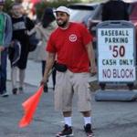 Parking attendant Earl Grant directed cars to a lot off Van Ness Street near Fenway Park on Monday.
