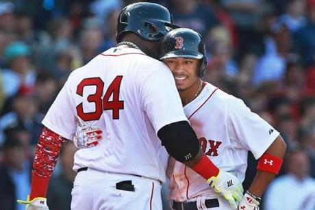 04/13/15: Boston, MA: The Red Sox Mookie Betts is greeted with a hug and a word by teammate David Ortiz following his second inning three run home run to put Boston ahead 4-0. The Boston Red Sox hosted the Washington Nationals in their home Opening Day MLB baseball game at Fenway Park. (Globe Staff Photo/Jim Davis) section: sports topic: Red Sox-Nationals (1)

