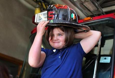 Jane Richard put on a firefighter?s helmet as the Richard family and Mayor Walsh visited the Boston Fire Department station on Boylston Street. on Wednesay. (metro)
