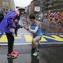 Dustin Hicks (right) of Temple Terrace, Fla, proposes marriage to Laura Bowerman after crossing the Boston Marathon finish line on Monday.