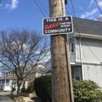 A sign posted to a utility pole across the street from a three-story house on the corner of Curry Circle and New Ocean Street. 
