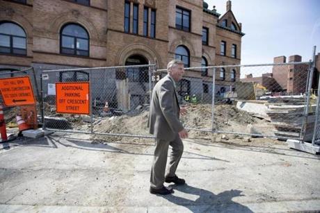 Gary Leonard, Brockton?s Main Street manager, walks past the nearly completed City Hall building. Under Leonard?s watch, vacant storefronts have been cut nearly in half in just nine months.
