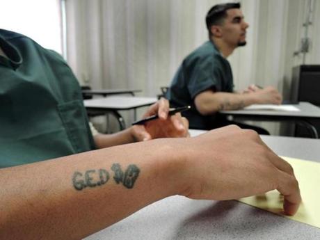 A GED tattoo motivates inmate Gerald Daughtry, Daniel Rexford (right) listens as Adam Frattasio explains mathematical concepts. 
