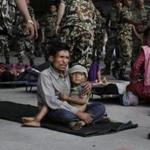 A man sat with a child on his lap as victims of Saturday?s earthquake, and waited for ambulances after being evacuated at the airport in Kathmandu on April 27. 