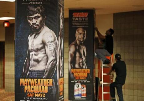 Workers install signs for the bout between Floyd Mayweather Jr. and Manny Pacquiao scheduled for Saturday.
