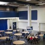 Students meet in a multipurpose room that serves as the cafeteria and auditorium at Minuteman High School. 