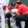 Hanley Ramirez is surrounded by his manager, a trainer, and teammates after running into the side wall in left.
