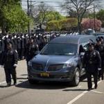 Police officers lined the streets as a hearse carrying the body of slain New York City Police Department officer Brian Moore proceeded to St. James Roman Catholic Church. 