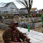 Mansfield Adams took a break while chatting with Kesiah Bascom and Alyssa Faulkner at one of Lowell's community gardens. Adams and Faulkner are gardener coordinators.
