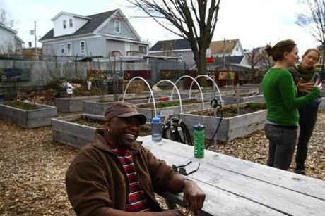 Mansfield Adams took a break while chatting with Kesiah Bascom and Alyssa Faulkner at one of Lowell's community gardens. Adams and Faulkner are gardener coordinators.
