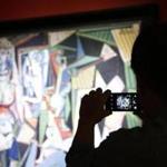 A person takes a cellphone photo of the Pablo Picasso painting 'Les femmes d'Alger (Version 'O'), oil on canvas on display prior an auction at Christie's in New York.