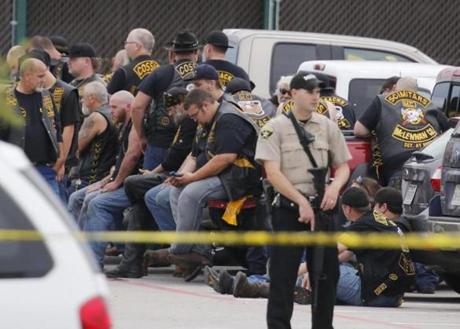 A deputy stood guard near a group of bikers in the parking lot of a Twin Peaks restaurant in Waco, Texas, on Sunday.
