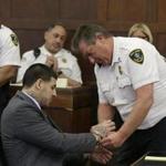 Aaron Hernandez hadhis handcuffs removed before his arraignment at Suffolk Superior Court on Thursday.