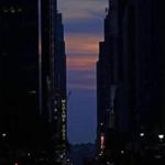 epa04774885 The sun is seen setting behind buildings on 42nd Street during the Manhattanhenge, a twice a year occurrence in which the setting sun aligns with the street grid of New York City, in Manhattan, New York , USA, 29 May 2015. This year the sun was mostly obscured by low-level clouds. EPA/PETER FOLEY