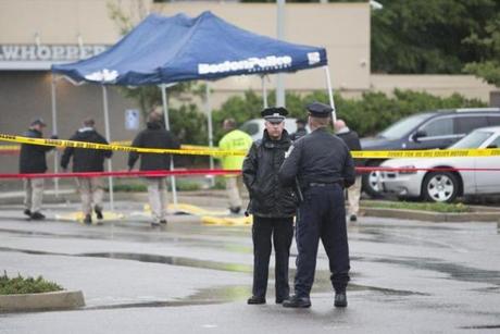 Evidence is covered and surrounded by police tape outside of CVS on Washington St. in Roslindale following an officer involved shooting on Tuesday, June 2, 2015. (Scott Eisen for The Boston Globe)
