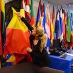 Student Joanna Konomi adjusted flags in Quincy College?s International Student Services office.