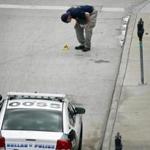 FBI investigators examined evidence on the sidewalk in front of Dallas police headquarters Saturday.
