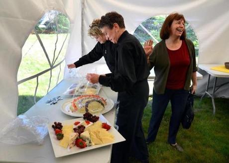 Olive Chase (right) talked to catering servers Kate Ryan (left) and Kitty Archer as they set up for an event in Osterville.
