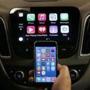 An iPhone is connected to a 2016 Chevrolet Malibu equipped with Apple CarPlay apps, displayed on the car's MyLink screen, top, during a demonstration in Detroit, Tuesday, May 26, 2015. Starting with Chevrolet this summer, many General Motors models will offer Apple?s CarPlay and Google?s Android Auto systems that link smart phones with in-car screens and electronics. (AP Photo/Paul Sancya)