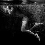 Underwater abstract portrait of young woman.