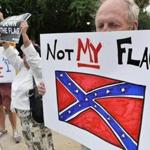 A man held a sign up during a protest rally against the Confederate flag, in Columbia, S.C., on Saturday.