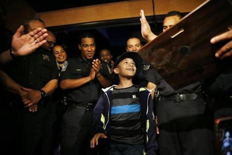 Divan Silva, 7, who was wounded while riding his bike, was applauded by officers at a party.
