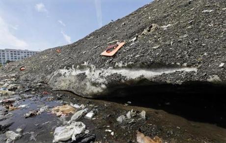 Debris covered the lingering South Boston snow pile at the end of May. 
