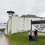Visitors took a picture Monday in front of the Clinton Correctional Facility in Dannemora, N.Y., one day after the search ended for two killers who escaped from the prison.