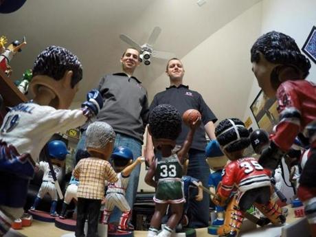 In this April 16, 2015, photo, Phil Sklar, left, and Brad Novak sit with some of the bobbleheads they have collected since quitting their jobs last year to start the National Bobblehead Hall of Fame and Museum in downtown Milwaukee. They?ve already collected 4,000 bobbleheads of sports players, mascots, characters, regular and famous people and hope to have 10,000 by the time they open next year. (AP Photo/Carrie Antlfinger)
