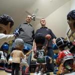 In this April 16, 2015, photo, Phil Sklar, left, and Brad Novak sit with some of the bobbleheads they have collected since quitting their jobs last year to start the National Bobblehead Hall of Fame and Museum in downtown Milwaukee. They?ve already collected 4,000 bobbleheads of sports players, mascots, characters, regular and famous people and hope to have 10,000 by the time they open next year. (AP Photo/Carrie Antlfinger)