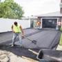 Workers resurfaced a residential driveway. A Wilmington firm has created a plant-based compound that could replace traditional asphalt.