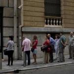 People lined up Tuesday to withdraw cash from a bank machine in central Athens. Limits remain on ATM withdrawals in Greece, and banks in the country are still closed.