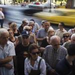 Pensioners wait outside the main gate of the national bank of Greece to withdraw a maximum of 120 euros ($134) in central Athens, Thursday, July 9, 2015. With a deadline just hours away to come up with a detailed economic reform plan, Greece requested a new three-year rescue from its European partners Wednesday as signs grew its economy was sliding toward free-fall without an urgently needed bailout. (AP Photo/Emilio Morenatti)