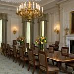 The State Dining room of the White House has been refurbished with new arm chairs, side chairs, and draperies suspended from carved and gilded poles.