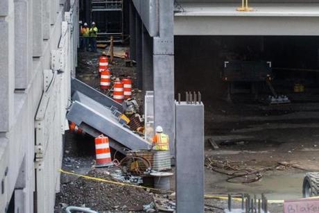 Workers looked at a large slab of concrete that could be seen wedged between the Central Garage and an extension being built at Logan. 
