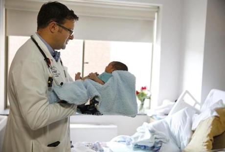 Dr. Dan Hale (above) checks in on newborn Nazierre Sanchez as he makes patient rounds at Lawrence General Hospital.  
