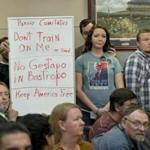 Bob Welch (standing, at left) and Jim Dillon held a sign at a public hearing about the Jade Helm 15 military training exercise in Bastrop, Texas, last April.