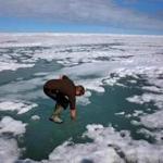 Researcher Josh Jones stood on the Arctic ice and put his arm in to see how salty the water might be at Barrow, Alaska.