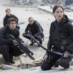 From foreground: Jennifer Lawrence as Katniss Everdeen, Liam Hemsworth as Gale Hawthorne, Sam Claflin as Finnick Odair, and Evan Ross as Messalla in 