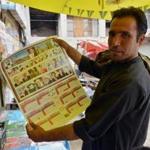 A clerk in Kandahar on Thursday held up a calendar that included a picture of the late Mohammad Omar.