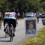 Riders passed by signs of children helped by the Jimmy Fund as they participate in the Pan-Mass Challenge in Lakeville on Saturday. 