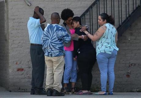 A family member of one of the victims is comforted near the shooting scene in Roxbury.
